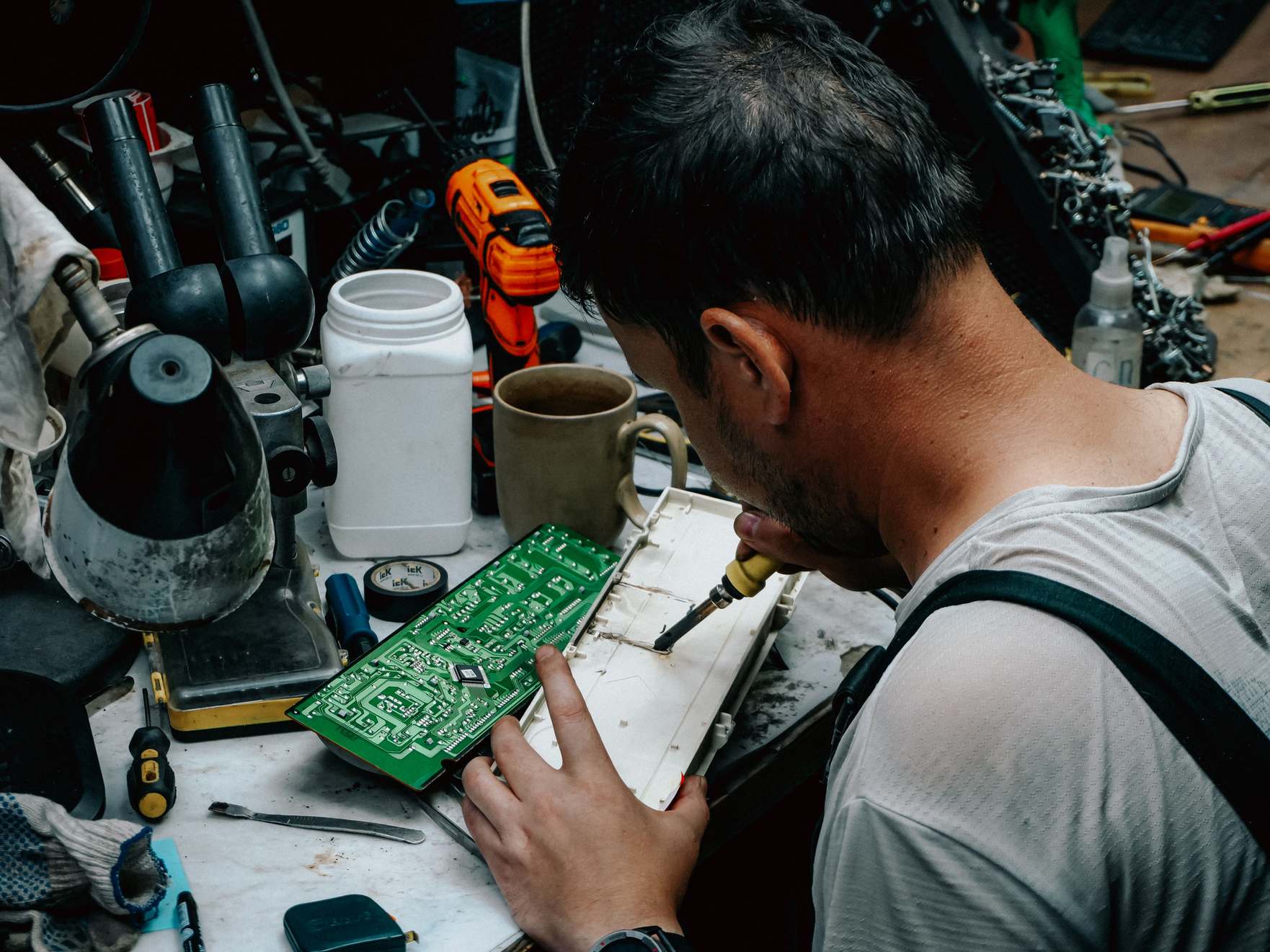 Close view of circuit board components, technician soldering a circuit board